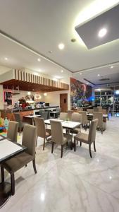 a dining room with tables and chairs in a restaurant at Front One Hotel Purwodadi in Purwodadi