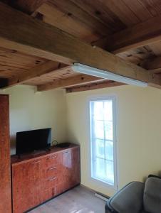 a living room with a tv and a window at Sumski raj Gornje podunavlje in Sombor