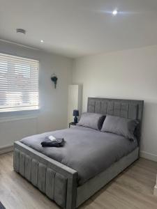 a bedroom with a large bed in a white room at CoolSideOfThePillow in Swindon