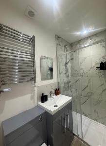 a bathroom with a sink and a shower at CoolSideOfThePillow in Swindon