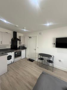 a kitchen with white cabinets and a table in it at CoolSideOfThePillow in Swindon