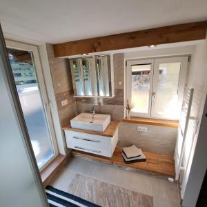 a bathroom with a sink and two windows at "Hisel-Haus" in Techelsberg am Worthersee +21 photos