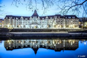 a large building with its reflection in the water at Chez Marie et Guy 