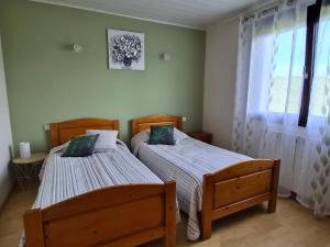 two twin beds in a room with a window at Chez Marie et Guy 