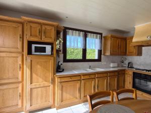 a kitchen with wooden cabinets and a microwave at Chez Marie et Guy 