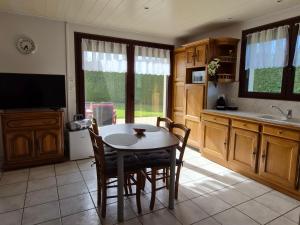 a kitchen with a table and chairs and a tv at Chez Marie et Guy  +24 photos