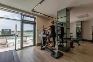 a woman on a treadmill in a gym with a view at Monumenti Heritage Hotel&Resort in Pula