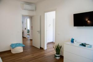 a white living room with a tv on a wall at G&G Bed&Breakfast in Bonorva