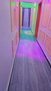 an empty corridor with colored lights on the floor at Postive Vibes Hotel and Bar in Ikotun