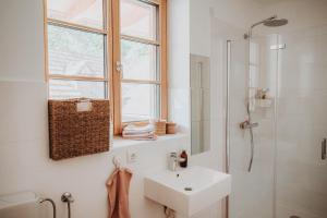 a white bathroom with a sink and a shower at Der Yogahof in Tratten +16 photos