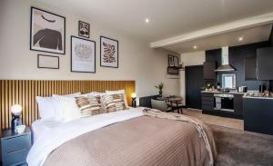 a bedroom with a large bed and a kitchen at The Mariner's Rest Aparthotel in Cleethorpes