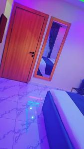 a room with a bed and two windows and a door at Postive Vibes Hotel and Bar in Ikotun