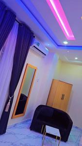 a room with a black chair and a mirror at Postive Vibes Hotel and Bar in Ikotun