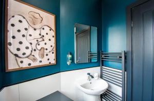 a blue bathroom with a sink and a mirror at The Mariner's Rest Aparthotel in Cleethorpes