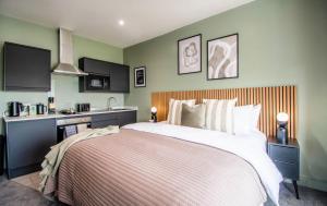a bedroom with a large bed and a kitchen at The Mariner's Rest Aparthotel in Cleethorpes +51 photos