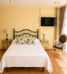 a bedroom with a bed and a television on the wall at Holibai Misiño, Estudio para dos en Baiona in Baiona