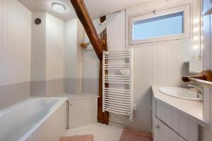 a bathroom with a tub sink and a window at Chalet La Grange Courchevel in Courchevel +35 photos