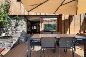 a wooden table and chairs on a deck at Chalet La Grange Courchevel in Courchevel