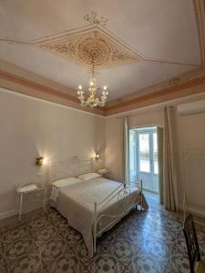 a bedroom with a bed and a ceiling with a chandelier at A Casa ra Signurina in Modica
