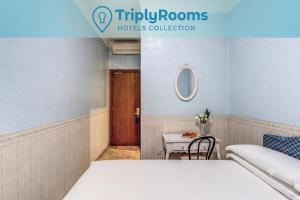 a bedroom with a bed and a table and a door at TriplyRooms Collection - Roma Colosseo in Rome