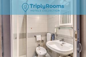 a white bathroom with a sink and a toilet at TriplyRooms Collection - Roma Colosseo in Rome