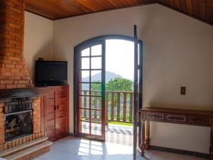 a living room with an open door to a balcony at Pousada Bela Mauá in Itatiaia
