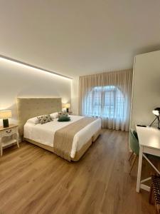 a bedroom with a bed and a desk and a window at Apartamentos Las Alas in Cartes