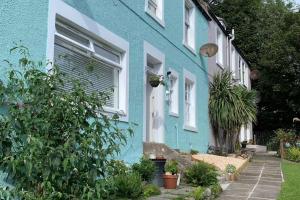 a blue and white house with plants in front of it at Largo Bay - Harbour Hideaway in Leven