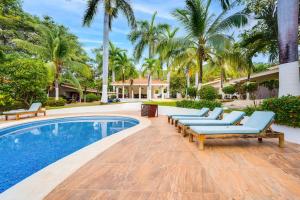 a swimming pool with lounge chairs and palm trees at Club Voca 5 in Coco +10 photos