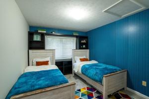 two beds in a room with blue walls at Cedar Retreat in McGaheysville