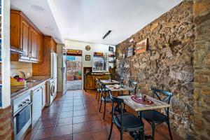 a kitchen with two tables and a stone wall at El Regreso in Jarilla