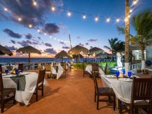 a restaurant on the beach with tables and chairs at Club Regina Cancun in Cancún