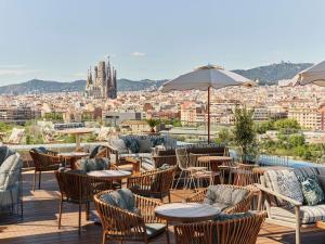 a patio with tables and chairs and a view of a city at The Hoxton, Poblenou in Barcelona