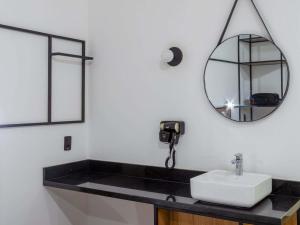 a bathroom with a sink and a mirror at ibis Jaú in Jaú +59 photos