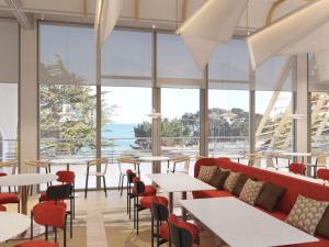 a restaurant with tables and chairs and large windows at Domaine des Grands Sables, Île Groix - Handwritten Collection in Groix