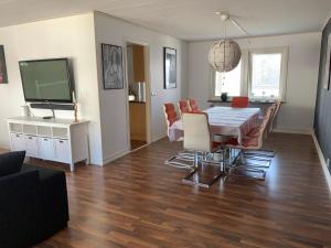 a living room with a table and chairs and a television at Ronneby Torneryd Retreat in Ronneby