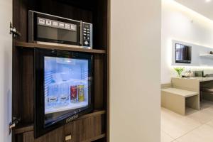 a television in a cabinet with a refrigerator at Toledo 16 Luxury Suites in Naples