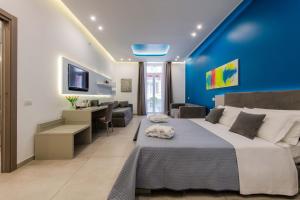 a bedroom with a large bed with a blue wall at Toledo 16 Luxury Suites in Naples +105 photos