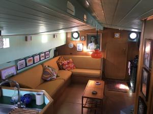 a living room with a couch and a table at Houseboat Zeldenrust in West Mersea