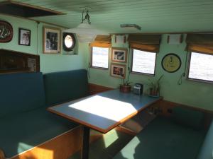a dining room with a table and a couch at Houseboat Zeldenrust in West Mersea