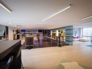 an open living room with a bar and a kitchen at Ibis Styles Linz in Linz