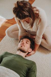 a woman standing on top of a man on the floor at Der Yogahof in Tratten