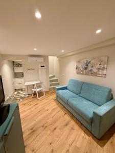 a living room with a blue couch and a kitchen at Casa Picicio in Assisi