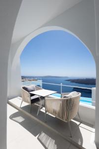 a balcony with a table and chairs on a ship at Cosmopolitan Suites - Small Luxury Hotels of the World in Fira