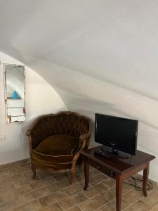 a living room with a chair and a television on a table at Dimora Lieta in Pisticci