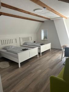 two beds in a room with wooden floors at Altes Vogtshaus in Weil am Rhein