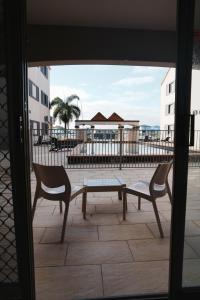 a patio with two chairs and a bench and a table at Hope Harbour Hotel Apartments in Gold Coast