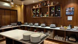 a kitchen with a counter with plates and dishes at Hotel Divine Lakshmi Ganga in Rishīkesh