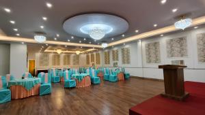 a room with blue tables and chairs and a podium at Hotel Divine Lakshmi Ganga in Rishīkesh +100 photos
