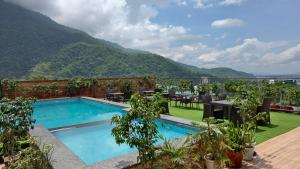 a swimming pool with a view of a mountain at Hotel Divine Lakshmi Ganga in Rishīkesh